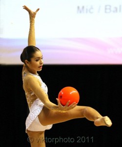 Погрузитесь в мир гимнастки Юлии Синицыной, пленяющей взгляд своими танцующими движениями в купальнике.